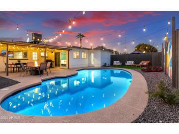 Inviting kidney-shaped pool with patio and string lights; perfect for entertaining at 2401 N 37Th St, Phoenix, AZ 85008