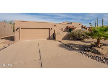 Tan stucco house with a two-car garage and desert landscaping at 18548 E Parada Cir, Rio Verde, AZ 85263