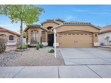 Tan two-story house with a two-car garage and landscaped front yard at 20906 N 36Th Pl, Phoenix, AZ 85050