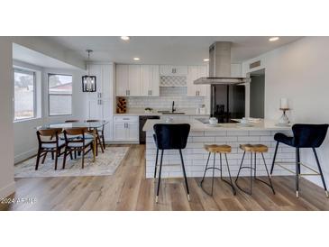 Modern kitchen with white cabinets, quartz countertops and island at 544 E Morrow Dr, Phoenix, AZ 85024