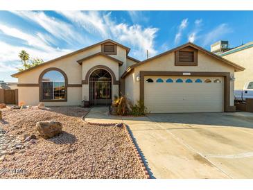 House exterior featuring a two-car garage and well-maintained landscaping at 2606 N 89Th Dr, Phoenix, AZ 85037