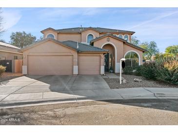 Two-story house with tan exterior, two-car garage, and landscaping at 2811 E Riviera Pl, Chandler, AZ 85249