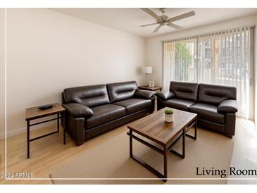 Spacious living room featuring two leather sofas, a coffee table, and ample natural light at 1701 E Colter St # 148, Phoenix, AZ 85016