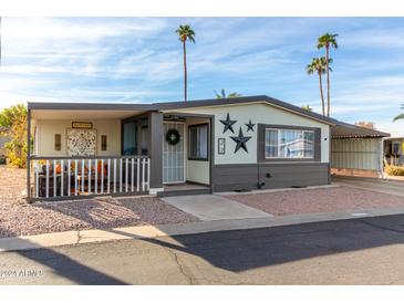 Inviting exterior of a manufactured home with a covered porch and landscaped yard at 3104 E Broadway Rd # 22, Mesa, AZ 85204