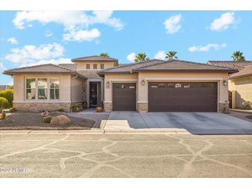 Tan two-story house with brown garage doors and desert landscaping at 4315 W Agave Ave, Eloy, AZ 85131