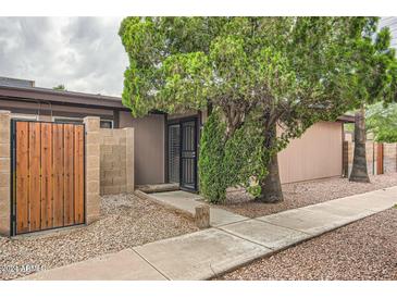 Tan house exterior with wood gate and mature landscaping at 828 S Hacienda Dr # B, Tempe, AZ 85281