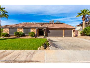 Single-story home with a three-car garage and well-manicured lawn at 1310 E Lynx Way, Chandler, AZ 85249