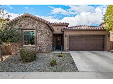 One-story home with stone and stucco exterior, two-car garage, and landscaped front yard at 17539 W Buchanan St, Goodyear, AZ 85338