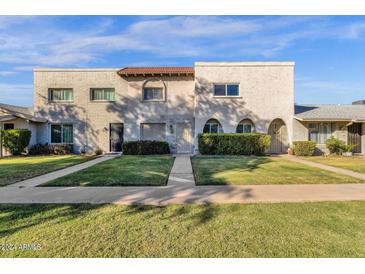 Front view of a two-story townhome with well-manicured lawn at 225 N Standage -- # 10, Mesa, AZ 85201