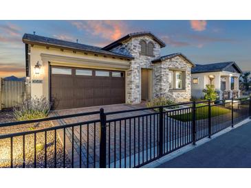 Attractive single-story home with stone exterior, a two-car garage, and a landscaped front yard at 5745 E Sierra Morena St, Mesa, AZ 85215