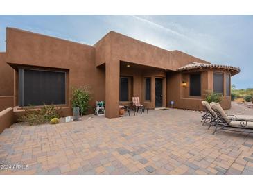 Front exterior of a Southwestern style home with a courtyard entry and seating area at 10751 E Cactus View Cir, Gold Canyon, AZ 85118