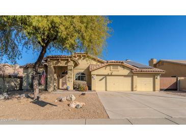 Single-story home with a two-car garage, solar panels, and mature landscaping at 10773 S Xavier Ct, Goodyear, AZ 85338