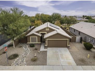 Single-story house with solar panels, desert landscaping, and a two-car garage at 1563 E Peregrine Trl, Casa Grande, AZ 85122