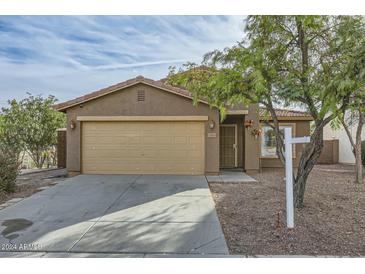 Beige house with a two-car garage and a landscaped front yard at 25763 W Satellite Ln, Buckeye, AZ 85326