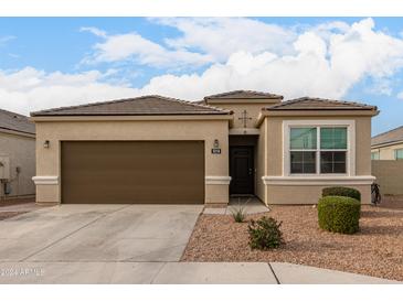 One-story home with brown garage door and neutral exterior at 5218 W Stargazer Pl, Laveen, AZ 85339