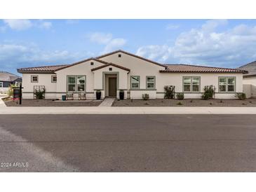 Single-story home with a Spanish-style facade and landscaped front yard at 10986 N Northfield St, Surprise, AZ 85388
