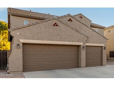 Two-story house with three car garage and desert landscaping at 11867 W Grant St, Avondale, AZ 85323