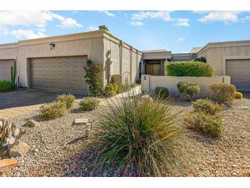 Front view of a charming stucco home with a two-car garage and well-manicured landscaping at 16111 E Kingstree Blvd # 5, Fountain Hills, AZ 85268