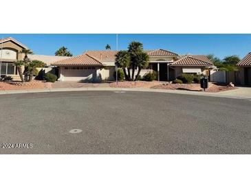 Single-story home with tile roof, desert landscaping, and a two-car garage at 13912 W Pavillion Dr, Sun City West, AZ 85375