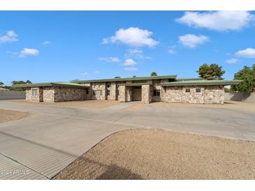 Stone exterior home with a large driveway and landscaped yard at 5540 E Shea Blvd, Scottsdale, AZ 85254