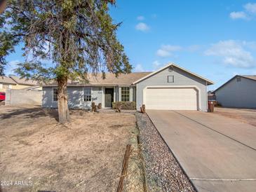 Charming single story home with a two car garage and mature tree in the front yard at 9322 E Des Moines St, Mesa, AZ 85207