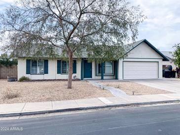 Single-story house with a green door and attached garage, landscaping, and a tree in the front yard at 2305 E Carol Ave, Mesa, AZ 85204