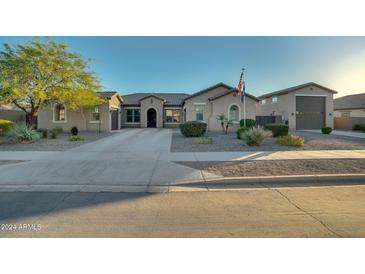 Single-story home with a large front yard, driveway, and attached garage at 21999 E Camacho Rd, Queen Creek, AZ 85142