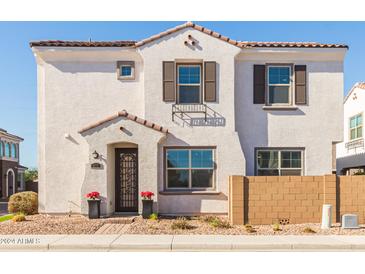 Two-story home with white stucco exterior, brown garage door, and landscaping at 678 N Bay Dr, Gilbert, AZ 85233