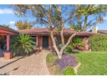 Brick ranch home with mature landscaping and a spacious front yard at 1310 W Marshall Ave, Phoenix, AZ 85013