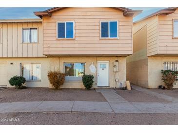 Tan two-story townhome with a small front yard and walkway at 3605 W Bethany Home Rd # 21, Phoenix, AZ 85019