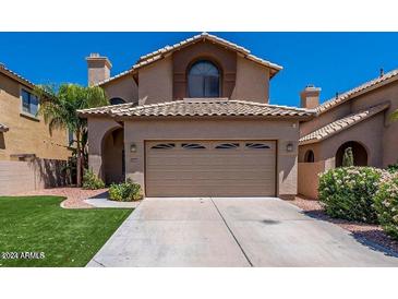 Two-story house with tan exterior, tile roof, and a two-car garage at 1206 E Villa Rita Dr, Phoenix, AZ 85022