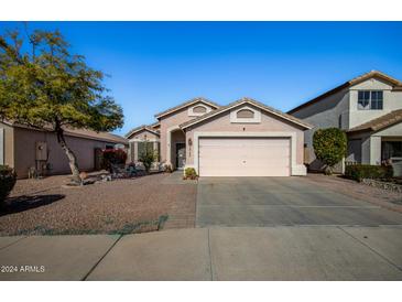 Cute one-story house with a pink garage door and well-maintained landscaping at 12742 W Ash St, El Mirage, AZ 85335