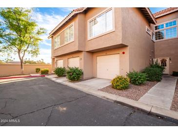 Tan two-story building with attached garages and landscaping at 1633 E Lakeside Dr # 77, Gilbert, AZ 85234