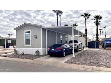 Mobile home with carport, landscaping, and storage shed at 2060 N Center St # 58, Mesa, AZ 85201