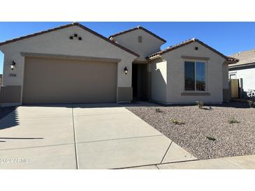 Attractive single-story home with a two-car garage and desert landscaping at 27036 N 168Th Ln, Surprise, AZ 85387