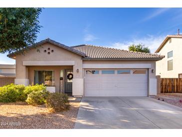 Charming single-story home with a two-car garage and well-manicured landscaping at 13928 N 145Th Ln, Surprise, AZ 85379