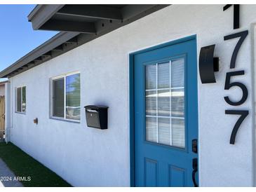 Updated home exterior with teal front door and modern house numbers at 1757 W Sunland Ave, Phoenix, AZ 85041