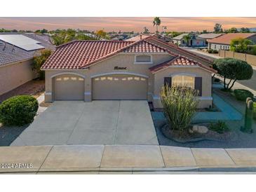 Single-story home with tile roof, two-car garage, and desert landscaping at 17649 W Stinson Dr, Surprise, AZ 85374