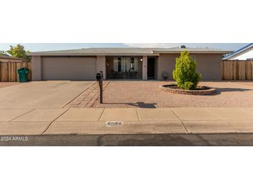 Ranch style home with a landscaped front yard, driveway, and attached garage at 6044 E Decatur St, Mesa, AZ 85205