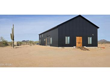 Modern black barn-style home with desert landscaping at 30314 W Wildcat Dr, Wittmann, AZ 85361