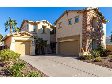 Two-story home with stone accents and a three-car garage at 660 E Riviera Dr, Chandler, AZ 85249