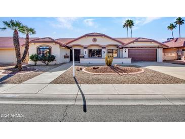 Single-story home with desert landscaping and a two-car garage at 14523 W Ravenswood Dr, Sun City West, AZ 85375