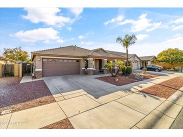 House exterior view, featuring a two-car garage and neatly landscaped front yard at 17867 W Eugene Ter, Surprise, AZ 85388