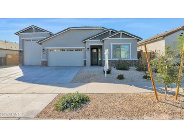 Two-story house with a gray exterior, two-car garage, and landscaped yard at 19027 W Sierra St, Surprise, AZ 85388