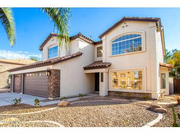 Two-story house with a three-car garage and desert landscaping at 1005 E Stirrup Ln, San Tan Valley, AZ 85143