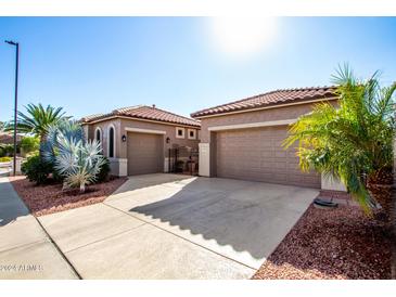 Front view of house with two-car garage and gated courtyard entry at 17937 W Weatherby Dr, Surprise, AZ 85374