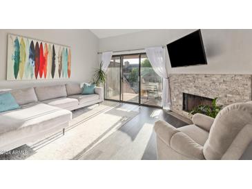 Bright living room with fireplace and sliding glass door to balcony at 5998 N 78Th St # 216, Scottsdale, AZ 85250