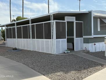 Mobile home with covered patio and screened enclosure at 9501 E Broadeway Rd # 50, Mesa, AZ 85208