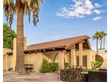 Spanish style home with terracotta roof, lush landscaping, and a covered patio at 2835 N 77Th Pl, Scottsdale, AZ 85257