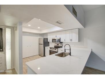 Modern kitchen with white cabinets, stainless steel appliances, and quartz countertops at 910 N Center St # 24, Mesa, AZ 85201